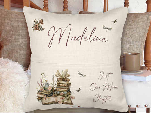 Linen Cushion with front pocket to hold a book. Personalised name on the top and a watercolour book and floral design with a quote reading Just one more Chapter.