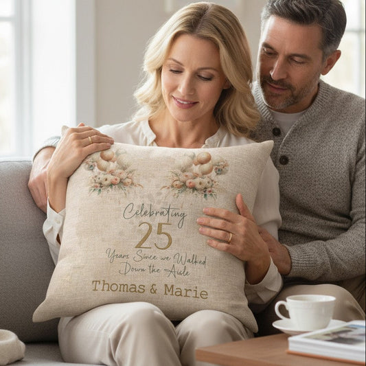 Couple holding an Anniversary cushion with balloons and florals