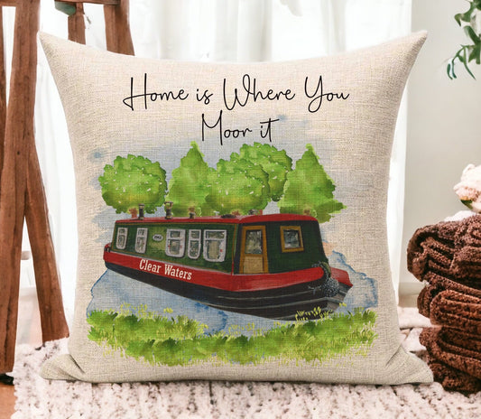 Beige linen cushion with a green and red narrowboat with water and trees. The name of the boat is on the side of it and the text reads &#39;Home is Where you Moor it&#39;