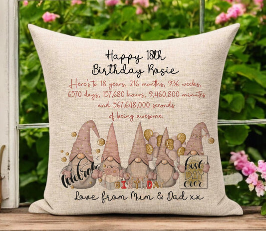 Cream beige linen 18th birthday cushion and cover with a gold and pink gonk theme with balloons and gifts. The text displays stats about how many weeks, years, months etc and 1 year old would be. It can be personalised top and bottom with names.